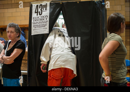 I Newyorkesi votazione sulla giornata primario nella palestra del PS 33 in New York quartiere di Chelsea il giorno delle elezioni Foto Stock