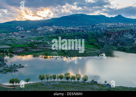 Nuvole illuminato Rising Sun e riflessa nel lago Foto Stock