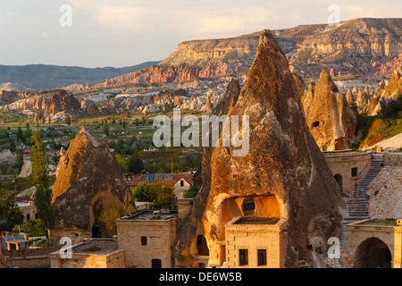 Camere Hotel tagliata nella roccia nella luce del sole al tramonto. Cappadocia, Turchia Foto Stock