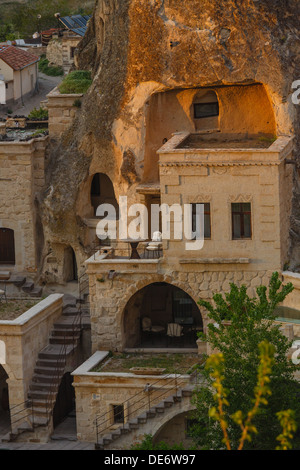 Camere Hotel tagliata nella roccia nella luce del sole al tramonto. Cappadocia, Turchia Foto Stock