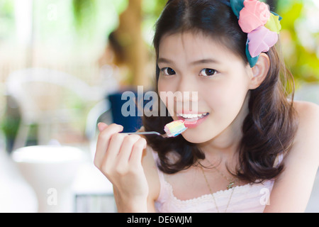 Ritratto ragazza tailandese di mangiare un cucchiaio di torta Foto Stock