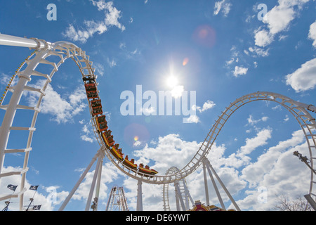 Un roller coaster con piloti in un parco di divertimenti. Foto Stock