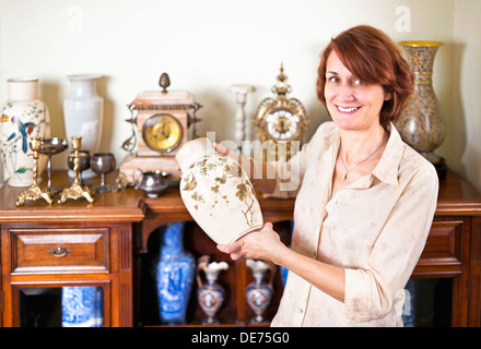 Orgogliosa donna vaso di contenimento dalla sua collezione di antichità Foto Stock