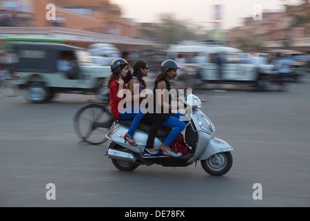 India Rajasthan, Jaipur, tre ragazze su uno scooter in ora di punta. Motion Blur effetto. Foto Stock