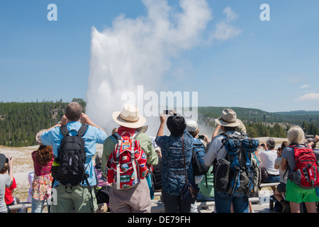 Fotografia di un gruppo di persone che godono di un'eruzione di Yellowstone il geyser Old Faithful. Foto Stock