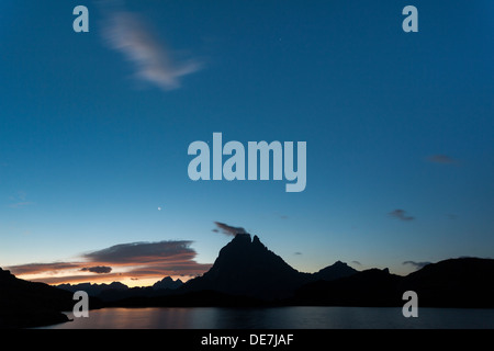 Il Midi d'Ossau al sorgere del sole con la luna nel lago Ayous, Pyrénées-Atlantiques, Francia, Europa Foto Stock