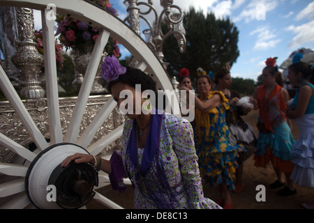 Le donne a piedi dietro un oxcart durante il pellegrinaggio al santuario della Vergine del Rocio nella provincia di Siviglia, Spagna Foto Stock