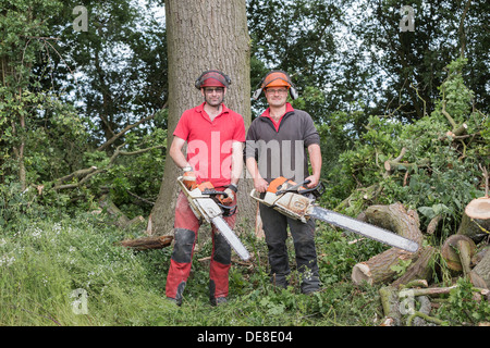 I chirurghi ad albero tenendo motoseghe a catena per i boschi. Foto Stock