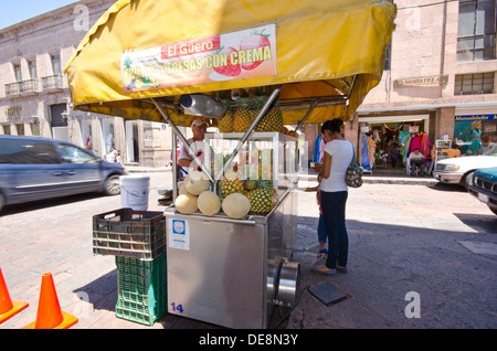 Fornitore su angolo di strada vendono frutta fresca dal suo cellulare stallo in Queretaro in Messico Foto Stock