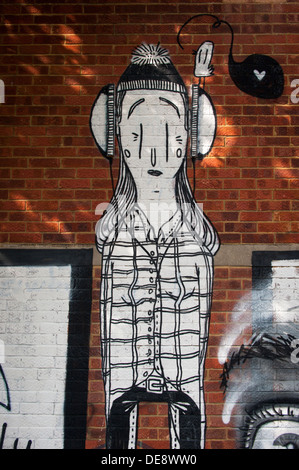 East End di Londra Isola di pesce Hackney Wick graffiti graffitti grafitti grafiti street arte urbana murale bianco nero cuffie cappellino da Alex Senna Foto Stock
