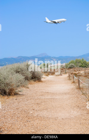 Jetliner sbarco in Son Sant Joan, aeroporto di Palma de Mallorca. In fondo è lo skyline di Palma con la cattedrale e la Città Vecchia. Foto Stock