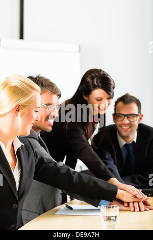 Business - gli imprenditori si riunione del team o di un workshop in un ufficio e unire le mani, è una molto buona squadra Foto Stock