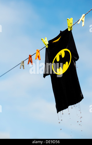 Childs wet batman t shirt appeso su una linea di lavaggio. India Foto Stock