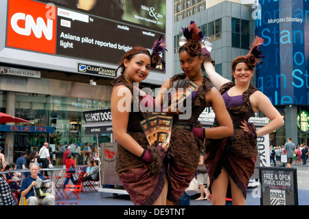 New York, NY - 11 Luglio 2013: tre donne abbigliate in costumi d'epoca holding locandine pongono Times Square. Foto Stock