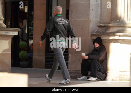 Un ubriaco senzatetto mendica per soldi sporchi, poveri, povertà, senzatetto e da solo Argyll Street, Glasgow, Scotland, Regno Unito Foto Stock