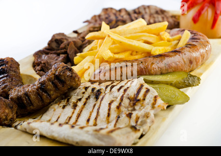 Vassoio rustico con vari tipi di carne, patatine fritte e ortaggi assortiti Foto Stock