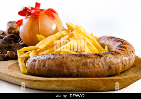 Vassoio rustico con vari tipi di carne, patatine fritte e ortaggi assortiti Foto Stock