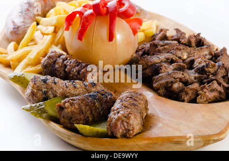 Vassoio rustico con vari tipi di carne, patatine fritte e ortaggi assortiti Foto Stock