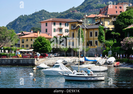 Italia - Lago di Como - Varenna - vista lago a piedi - ormeggiate barche - Riflessioni - case di villaggio - tetti arancione - Montagna Foto Stock