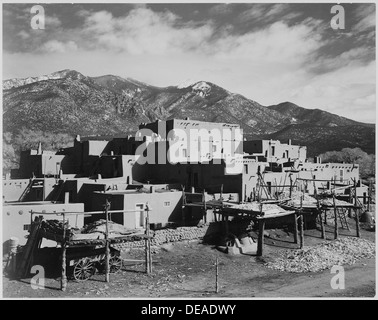 Vista completa della città, montagne sullo sfondo, Taos Pueblo Pietra Miliare Storica Nazionale, Nuovo Messico, 1941. , 1941 519984 Foto Stock