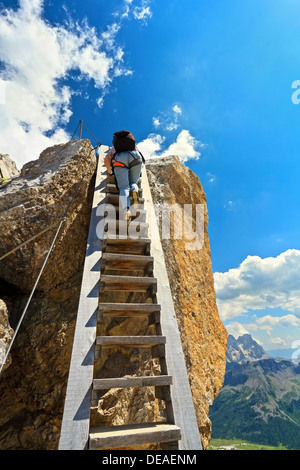 Escursionista su grande scala in legno in Bepi Zac via ferrata, Trentino, Italia Foto Stock