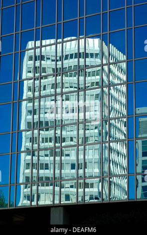 Il grattacielo dell'Unione internazionale delle telecomunicazioni si riflette nella facciata di vetro di un edificio adiacente, Ginevra Foto Stock