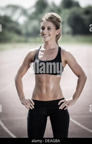Tonica donna sorridente dopo allenamento fitness Foto Stock