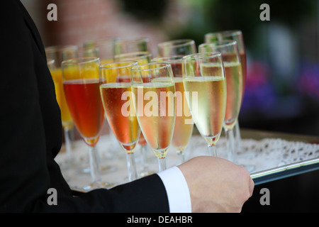 Vassoio di coloratissimi bicchieri riempiti con Champagne Foto Stock