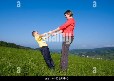 La madre, 30 anni, e il figlio di 6 anni, giocando in un prato Foto Stock