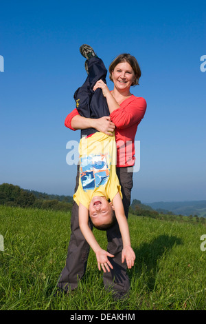 La madre, 30 anni, e il figlio di 6 anni, giocando in un prato Foto Stock