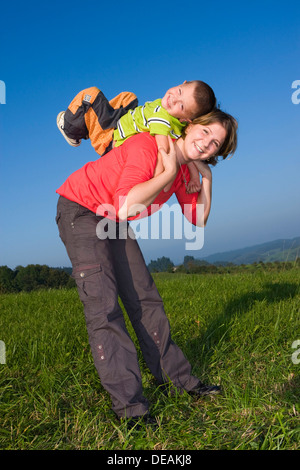 La madre, 30 anni, e il figlio di 6 anni, giocando in un prato Foto Stock