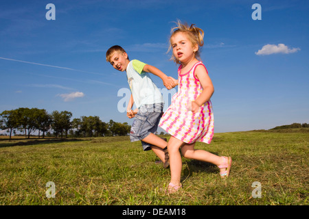 Bambina di 3 anni e suo fratello, 7 anni, all'aperto Foto Stock