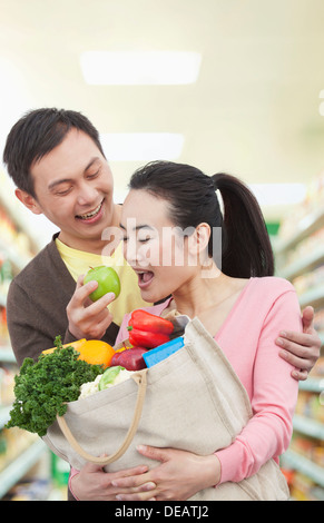 Uomo Donna di alimentazione Apple nel negozio di alimentari Foto Stock