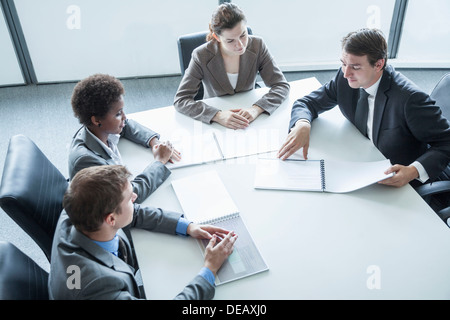 Quattro persone sedute intorno ad un tavolo e avente una riunione di affari, ad alto angolo di visione Foto Stock