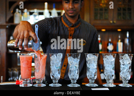 Il barista al Raffles Hotel di Singapore rendendo il famoso cocktail Singapore Sling bere Foto Stock