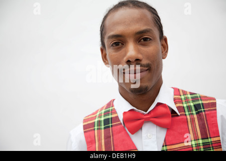 Ritratto di giovane uomo in plaid gilet rosso e il filtro bow tie, studio shot Foto Stock