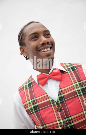 Ritratto di giovane uomo in plaid gilet rosso e il filtro bow tie, studio shot Foto Stock