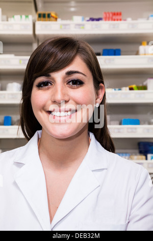 Ritratto di sorridente giovane farmacista guardando la telecamera in una farmacia Foto Stock