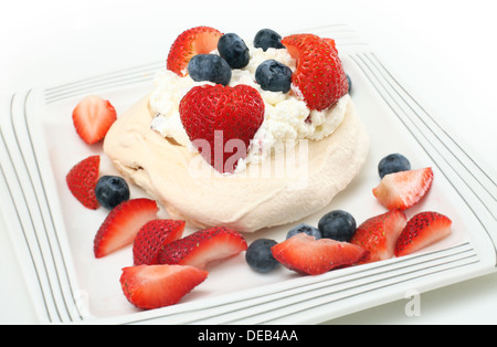 A casa di singoli fragola e mirtillo pavlova (meringa guarnita con crema dessert). Foto Stock
