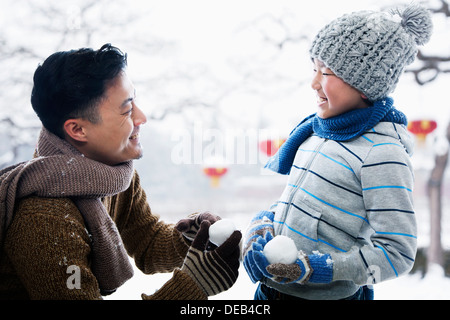 Padre e figlio azienda snowballs Foto Stock