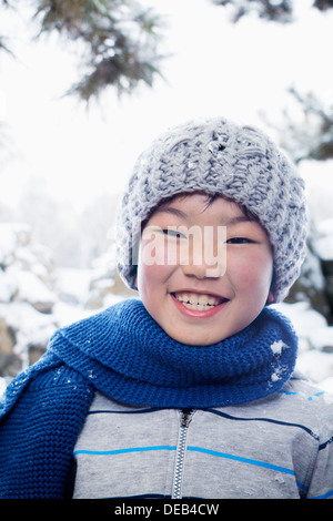 Ragazzo sorridente nella neve, ritratto Foto Stock