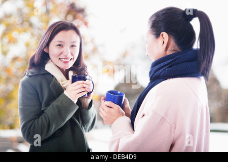 Due amici con bevande calde Foto Stock