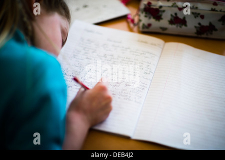 Una ragazza pupillo la scrittura in lingua gallese in una scuola primaria, Wales UK Foto Stock