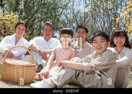 Ritratto di un multi-generazionale famiglia avente un picnic e godere del parco di primavera Foto Stock