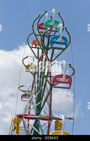 La gente ride un colorato, ruota panoramica Ferris fortemente contrastata contro un profondo cielo blu con puffy nuvole bianche presso la Fiera di Stato in NC Foto Stock