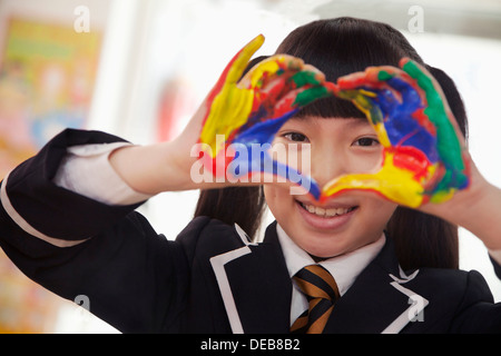 Sorridente schoolgirl dito pittura, close up sulle mani Foto Stock