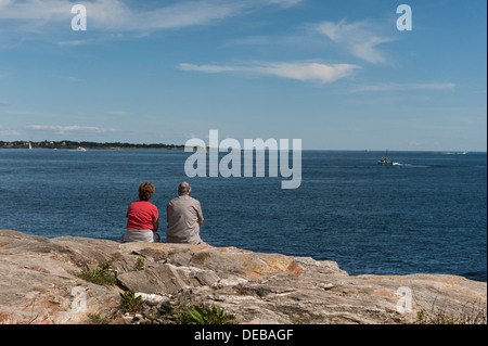 Una coppia di anziani seduti sulle rocce che si affacciano sull'oceano nel punto Judith, Rhode Island, STATI UNITI D'AMERICA Foto Stock