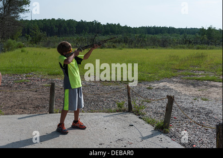 Giovane ragazzo skeet tiro a Ocala National Forest pubblico Tiro a segno sulla Strada Statale 40 in Ocala, Florida USA Foto Stock