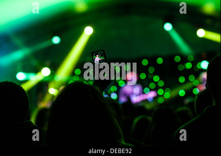 Membro del pubblico la registrazione di una band sul loro telefono mobile al grande tributo Music Festival, Agosto Weekend Festivo Wales UK Foto Stock