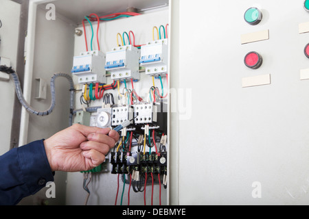 Close-up dei lavoratori mano il controllo dei comandi e il cablaggio di un impianto a gas, Pechino, Cina Foto Stock